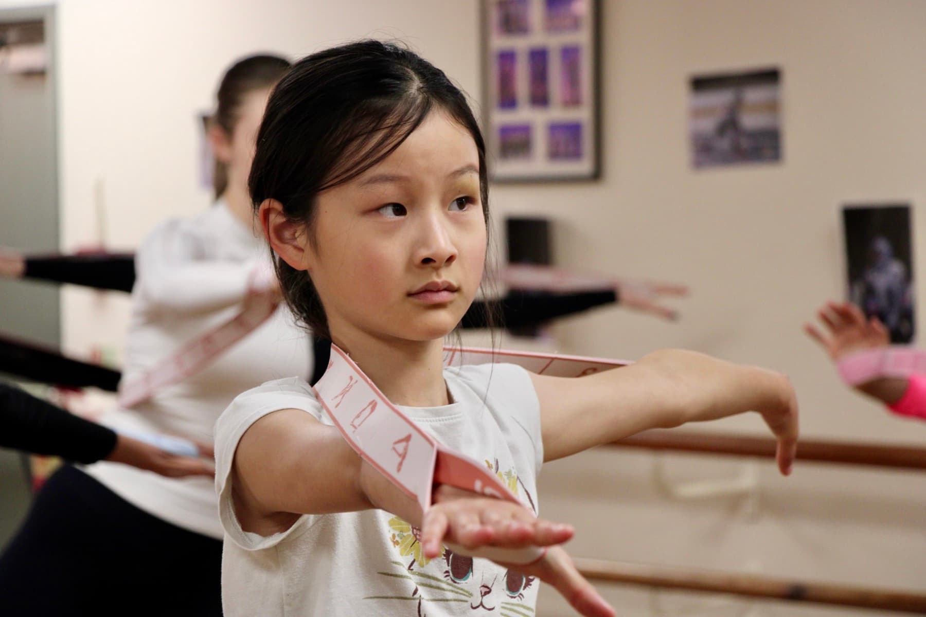 A young skater working through an off-ice class at the barre