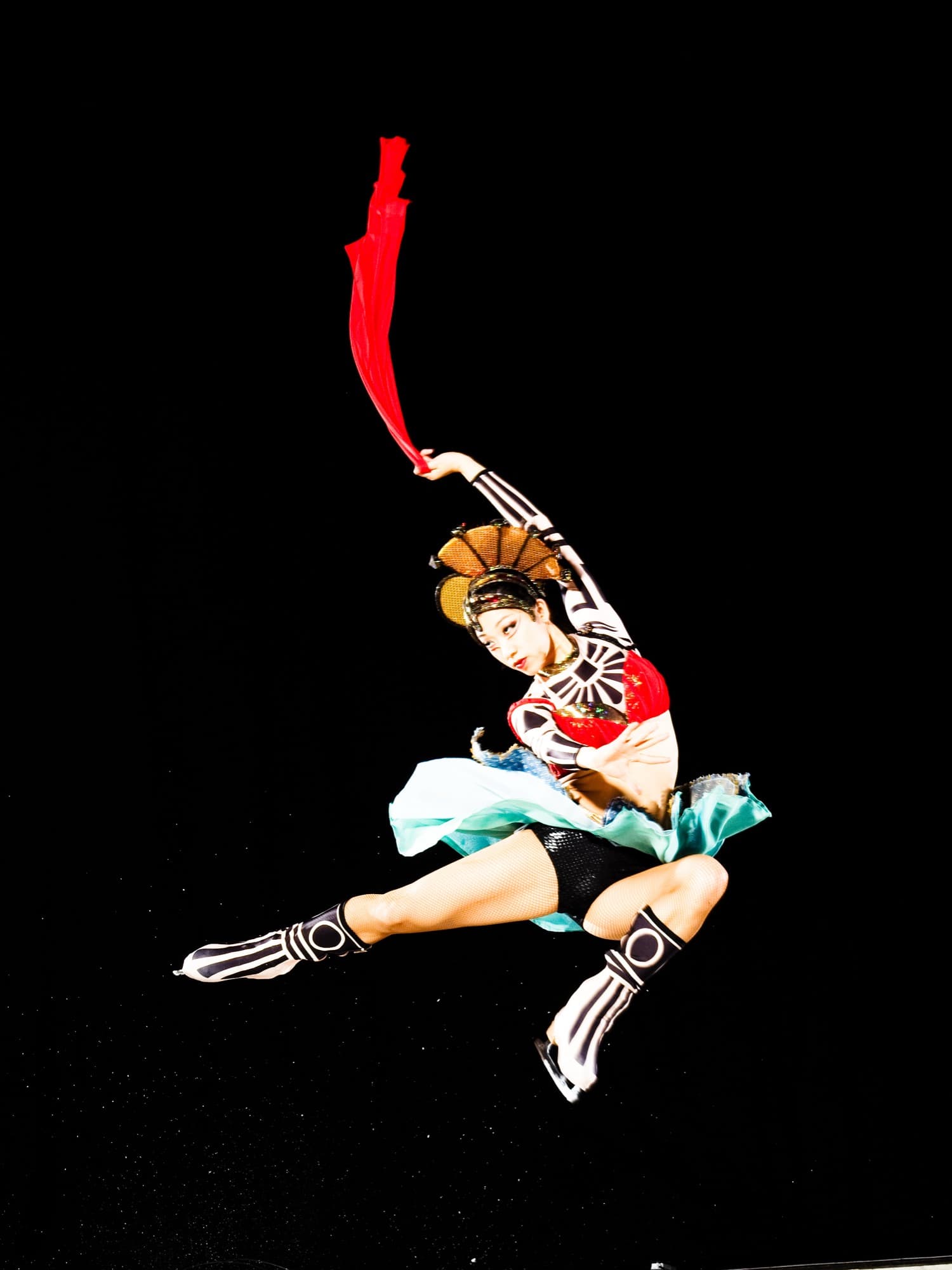 Yebin performing in costume with a red fan trailing above her