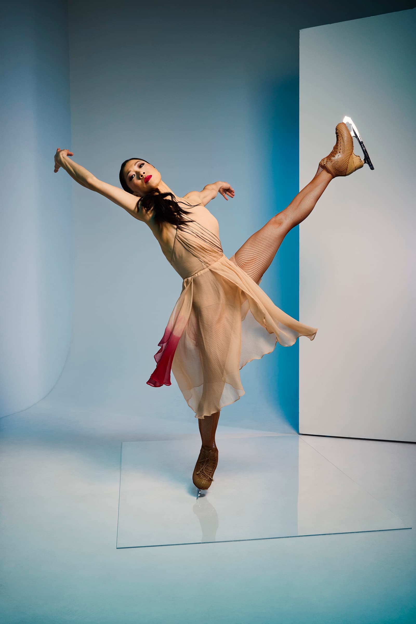 Yebin in a peach dress, arms open and blade high behind her